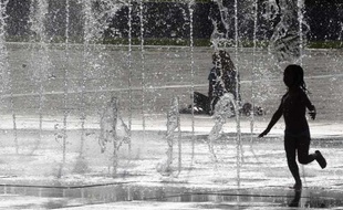 Des enfants se rafraichissent dans une fontaine à Colmar, dans le Haut-Rhin, lors d'une période de forte chaleur dans la région, le 29 juin 2012.