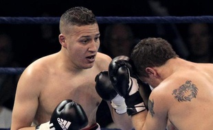 Le boxeur français Fatah Hou (g) à la lutte contre Maksims Ivancikovs durant un championnat du monde poids lourds, le 9 avril 2010, à Massy dans l'Essonne