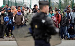 Photo d'archives du 28 mai 2014 à Calais, montrant des policiers face au migrants qui affluent, tentant de se rendre en Grande-Bretagne