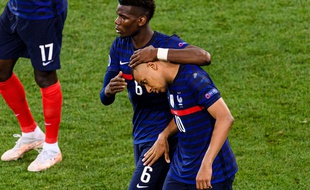 Paul Pogba console Kylian Mbappé après son tir au but manqué face à la Suisse, qui a précipité l'élimination de la France en 8es de finale de l'Euro, le 28 juin 2021 à Bucarest.