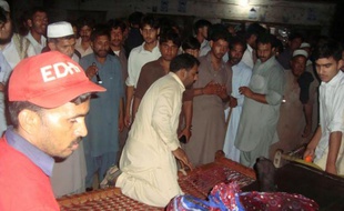 Des volontaires déplacent les corps des victimes du crash d'un hélicoptère militaire, près de Mansehra dans le nord-ouest du Pakistan, le 6 août 2015