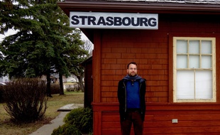 Jean-Yves Bart devant l'ancienne gare de Strasbourg dans la région canadienne du Saskatchewan.