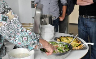 Angela Runge, 63 ans, sert le repas qu'elle a préparé pour les employés d'une entreprise informatique à Berlin, le 8 mai 2014