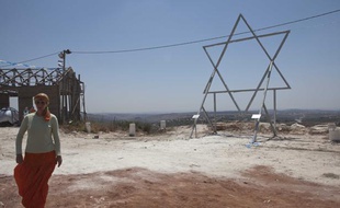 Un colon juif devant l'Etoile de David et un nouveau bâtiment en construction dans la colonie illégale de Ramat Gilad, en Cisjordanie.