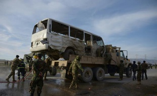 Des soldats afghans se tiennent près d'un bus contre lequel s'est jeté un kamikaze, tuant trois soldats, le 8 février 2016 à Dehdadi, dans l'agglomération de Mazar, en Afghanistan