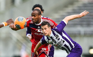 Le Lyonnais Jimmy Briand (en rouge) est devancé par le Toulousain Uros Spajic, lors de Toulouse - Lyon en Ligue 1, le 23 avril 2014.
