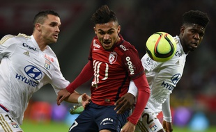 Lille's French midfielder Sofiane Boufal (C) vies with Lyon's French Cameroonian defender Samuel Umtiti (R) and Lyon's French defender Jeremy Morel during the French L1 football match between Lille (LOSC) and Lyon (OL) on February 21, 2016, at Lille Pierre Mauroy stadium in Villeneuve-d'Ascq, northern France. AFP PHOTO / DENIS CHARLET