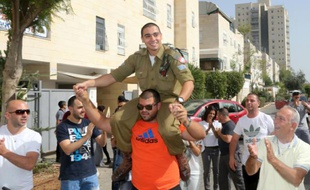 Elor Azria (c), soldat israélien inculpé d'homicide pour avoir achevé un assaillant palestinien blessé, en permission pour deux jours, le 22 avril 2016 à son arrivée chez lui à Ramla en Israël