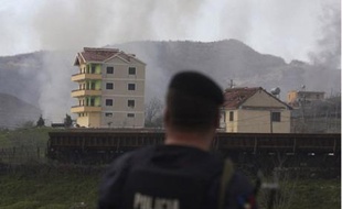 Un policier albanais contemple la base militaire touchée par une forte explosion, le 15 mars 2008.