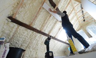 Travaux d'isolation du toit d'une maison.
