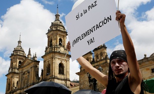 Un homme brandit une pancarte demandant la paix avec les Frac devant le parlement colombien à Bogota en Colombie.