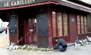 Un homme rend hommage aux victimes des attaques du restaurant "Le Carillon" , le 14 novembre 2015 à Paris