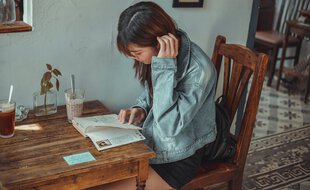 Une adolescente en pleine lecture chez elle.