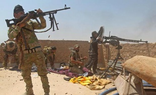 Des miliciens chiites irakiens le 25 mai 2015 au cours d'une opération pour tenter de reprendre une raffinerie de pétrole dans les environs de Baiji, au nord de Tikrit