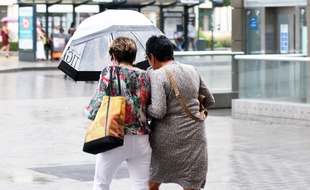 Deux femmes marchent sous la pluie avec un parapluie. Ici le 18 juillet, lors d'un orage à Rennes.