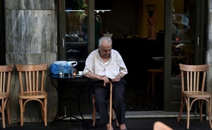 Un homme prend un café à la terrasse d'un bar dans le centre d'Athènes, le 13 juillet 2015