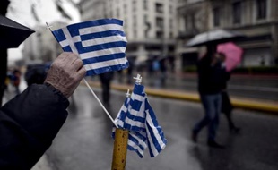 Un homme saisit un drapeau de la Grèce après une parade militaire dans le centre d'Athènes, lors de la fête de l'Indépendance, le 25 mars 2015