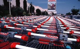 Rangées de caddies dans un supermarché Auchan.