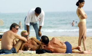 Un jeune Marocain approche des touristes le 12 juin 2001 sur la plage d'Agadir réputée pour le tourisme sexuel