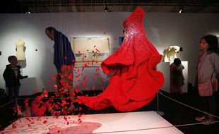 Visitors watch "Red Dress", a Lego sculpture by U.S. artist Nathan Sawaya presented during an exhibition The Art of the Brick, in Paris, France, Thursday May 14, 2015. The exhibition is created with Lego bricks and runs until Aug.30. (AP Photo/Christophe Ena)/ENA104/828093224202/1505141337