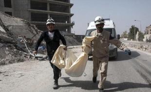 Des secouristes syriens transportent un corps, après une attaque supposée de l'armée syrienne aux barrils d'explosif sur un quartier rebelle, dans la ville d'Alep, le 9 juin 2015