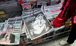 Une femme regarde dans un kiosque, le 6 janvier 2016 à Paris, le numéro spécial de Charlie Hebdo paru un an après l'attentat