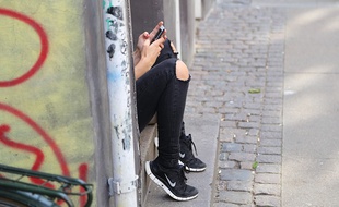 Une adolescente consulte son téléphone portable.