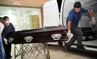 Des employés des pompes funèbres portent le cercueil d'un des huit Français morts dans le crash de leur hélicoptère pendant le tournage d'une émission télévisée en Argentine, le 17 mars 2015 à La Rioja, dans le nord-ouest du pays