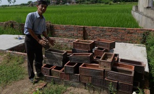 Nguyen Van Thao, un volontaire catholique vietnamien, montre de petits cercueils servant à enterrer des foetus dans un cimetière de la banlieue d'Hanoï, le 18 août 2014