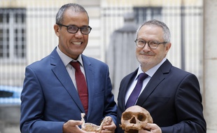 Le paléoanthropologue français Jean-Jacques Hublin (dr) et Abdelouahed Ben-Ncer (g) de l'Institut National d'Archéologie du Maroc posent en tenant dans leurs mains le crâne d'un Homo Sapiens vieux de 300.000 ans, le 6 juin à Paris.