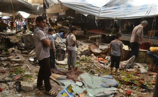 Des Syriens au milieu des décombres après des tirs attribués à des rebelles le 4 juin 2016 à al-Midan dans la banlieue d'Alep