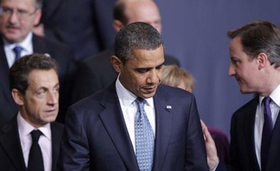 Le président français Nicolas Sarkozy et le Premier minstre David Cameron discutent derrière le président américain Barack Obama lors du sommet de l'Otan à Lisbonne, le 19 novembre 2010.