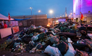 Des membres de la CGT se rassemblent près d'une amoncellement de déchets à Ivry-sur-Seine, près de Paris, le 10 juin 2016.