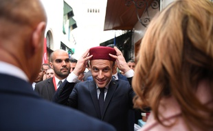 Le président Emmanuel Macron essaye un fez lors de sa visite de la médina de Tunis, le 1er février 2018.