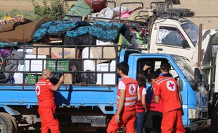 Des bénévoles de la Croix Rouge aident les réfugiés à rentrer en Syrie, le 23 juillet 2018.