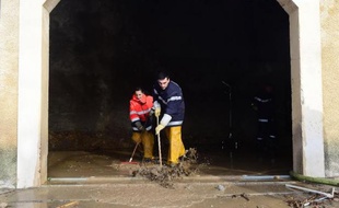 Des pompiers volontaires aident à nettoyer une maison après la crue de la Berre, à Portel-des-Corbières dans l'Aude, le 1er décembre 2014