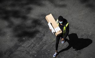 Paris, le 15 avril 2020. Un homme protégé d'un masque livre un colis Amazon en pleine épidémie de coronavirus.