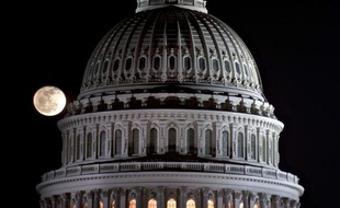 La lune se lève derrière le dome du Capitole, siège du congrès américain à Washington.