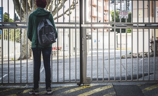 Un adolescent devant son lycée en avril 2020
