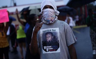 Un homme manifeste après la mort d'un jeune Noir tué par un policier, le 15 août 2014 à Ferguson dans le Missouri