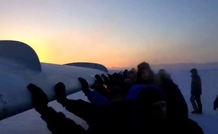 Capture d'écran d'une vidéo Youtube montrant des passagers pousser leur avion pour qu'il puisse décoller sur l'aéroport de la petite ville d'Igarka, en Sibérie, le 25 novembre 2014.