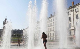 Des adolescents se rafraichissent dans une fontaine à Lyon, lors d'une période de forte chaleur dans la région, le 26 juillet 2012.