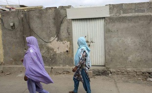 Deux femmes passent devant la maison de la jeune fille menacée de mort pour blasphème, à Islamabad.