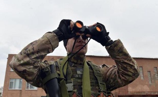 Un soldat ukrainien volontaire observe à la jummelle, le 26 février 2015 à Chermalyk, dans la région de Donetsk