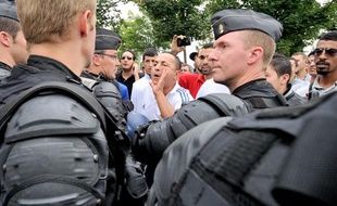 Un cordon de gendarme mobile protége le ministre de l'intérieur Manuel Valls qui est pris a parti par des habitants du quartier Nord d'Amiens à l'occassion de son déplacement le 14 Aout 2012 dans un quartier sensible d'Amiens aprés une nuit d'émeute ou plusieurs policiers ont été blésses.
