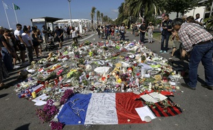 Des passant se recueillent sur la promenade des Anglais, à Nice, lundi 18 juillet.