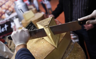 Illustration d'une personne tranchant du fromage, ici lors du Salon de l'agriculture à Paris.