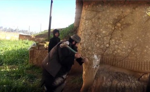 Image tirée d'une vidéo fournie par le groupe EI le 26 février 2015 montrant un militant détruisant une effigie de Lamassou, une divinité assyrienne, dans le nord du gouvernorat irakien de Ninive