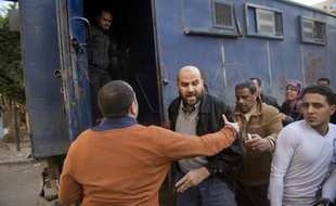 Un policier egyptien pousse un manifestant des Frères musulmans dans un fourgon, le 27 décembre 2013 au Caire