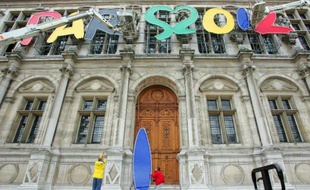 Des techniciens enlèvent les lettres du logo "Paris 2012" du fronton de l'Hôtel de Ville, le 8 juillet 2005 à Paris, deux jours après la victoire de Londres